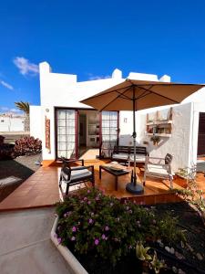 a patio with an umbrella and chairs and a table at La Casita Sun Beach in Caleta De Fuste