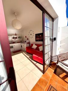 a living room with a red couch and a kitchen at La Casita Sun Beach in Caleta De Fuste +80 photos