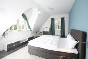 a bedroom with a large bed and a window at Strandhaus Buskam im Mönchgut auf Rügen in Lobbe