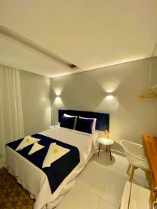 um quarto com uma cama grande e uma mesa em Pousada da Mana em Fernando de Noronha