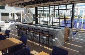 a restaurant with a bar with chairs and tables at Apart Hotel - Campos dos Goytacazes in Campos dos Goytacazes