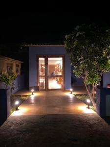 a wooden walkway with lights in front of a building at Pousada da Mana in Fernando de Noronha