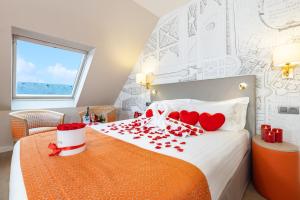 a bedroom with a bed with red hearts on it at Hotel Montbriand Antony - Ancien Alixia in Antony