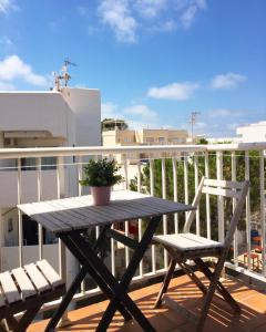 - Balcón con mesa de madera y 2 sillas en Apartamentos Formentera Copacabana 18, en Es Pujols