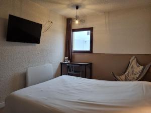 pokój hotelowy z łóżkiem i telewizorem z płaskim ekranem w obiekcie Bel Hotel w mieście Saint-Nicolas-de-Redon