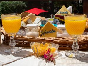 two glasses of orange juice and a basket of bread at Nereidas Apart in Mar de las Pampas