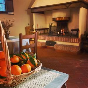 una cesta de naranjas en una mesa frente a una chimenea en Podere La Chiusella B&B, en Rapolano Terme