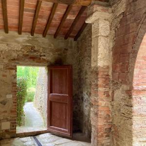 una entrada a un edificio de ladrillo con puerta de madera en Podere La Chiusella B&B, en Rapolano Terme