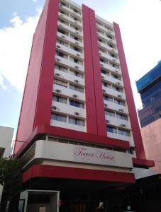 - un grand bâtiment rouge avec un panneau dans l'établissement Hotel Tower House Suites, à Panama City