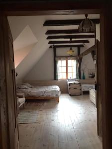a attic bedroom with two beds and a window at Sielski Zakątek Tokary in Tokary