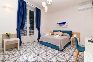Un dormitorio con una cama y cortinas azules y una ventana. en Antica Residenza Amalfitana, en Amalfi
