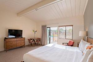 a bedroom with a bed and a television and a table at Contenta Inn in Carmel Valley
