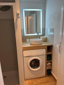 a bathroom with a washing machine and a sink at Maisonnette à 300 m du lac de Biscarrosse in Biscarrosse