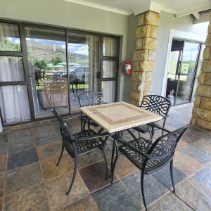 a table and chairs on a patio with a view of a porch at Villa Mohau 178 in Clarens