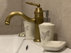 zlew w łazience ze złotym kranem i toaletą w obiekcie Ezüst Boróka Apartman w Egerze +37 zdjęć