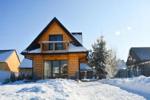 a log cabin with snow on the ground at Okno na gorce in Frydman