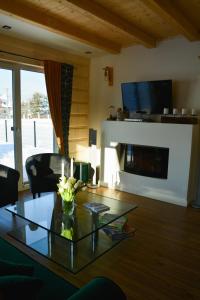 a living room with a glass table and a fireplace at Okno na gorce in Frydman