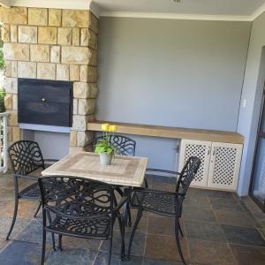 a table and chairs on a patio with a fireplace at Villa Mohau 178 in Clarens