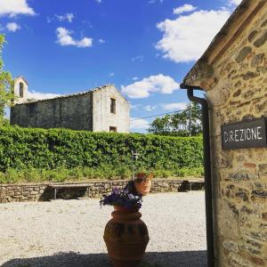 una maceta de flores al lado de un edificio en Podere La Chiusella B&B, en Rapolano Terme