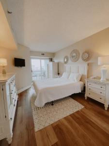 1 dormitorio con cama blanca y reloj en la pared en Watson's Regency Suites, en Ocean City