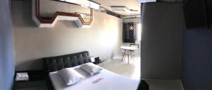 a bedroom with a bed with a black head board at Monza Hotel e Motel Adult Only in Santos
