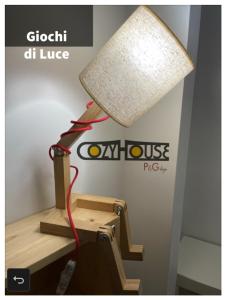una lámpara sobre una mesa con una luz encendida en Cozy House, en Enna