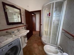 a bathroom with a washing machine and a sink at Agriturismo Pietramora in Pitigliano