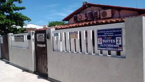 ein Zaun mit Schildern an der Seite eines Gebäudes in der Unterkunft Espaço das Estrelas repousadas Suites in Praia do Forte