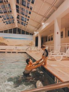 Un uomo e due ragazzi in una piscina di Watson's Regency Suites a Ocean City
