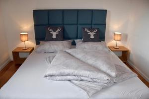 a bedroom with two beds with white sheets and two lamps at Ferienhaus Nockalmbahn in Bad Kleinkirchheim