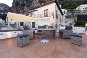 d'une terrasse avec des chaises en osier et une table. dans l'établissement Appartamento - Antica Residenza Amalfitana, à Amalfi