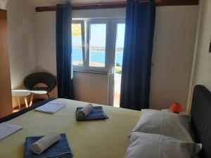 a room with a table with a view of the ocean at Apartments Donadic I, Caska in Novalja