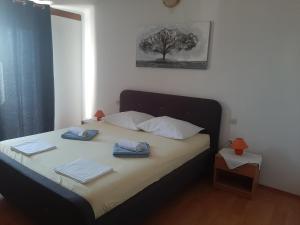 a bedroom with a bed with two towels on it at Apartments Donadic I, Caska in Novalja