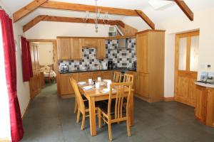 cocina con mesa de madera y sillas en Chy un Lur Rural cottage en Truro