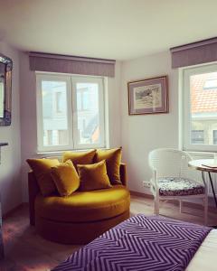 een woonkamer met een bank en 2 ramen bij B&B Belle de Nuit in Oostende