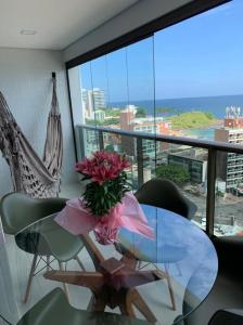 einen Glastisch mit einer Blumenvase darauf in der Unterkunft Barra 535 Vista Mar in Salvador