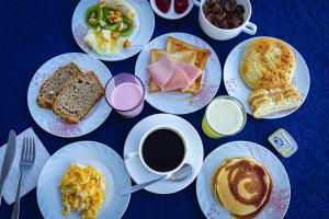 a table with plates of breakfast foods and a cup of coffee at Hotel Lago Azul in Copacabana