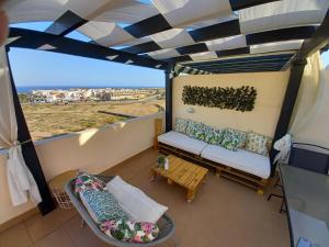 balcone con divano e tavolo di Atico con piscina privada a Vera