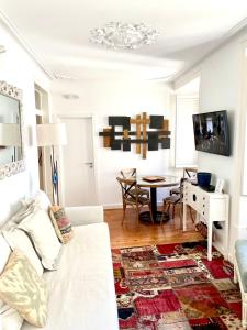 ein Wohnzimmer mit einem weißen Sofa und einem Tisch in der Unterkunft Bright and spacious three bedroom apt in the heart of Lisbon in Lissabon