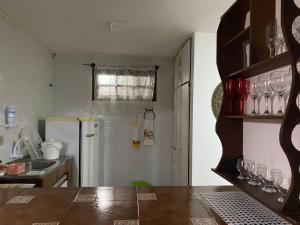 a kitchen with a refrigerator and some glasses on a shelf at Apartamentos Aconchegantes, Villa da Praia in Praia do Forte