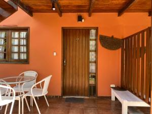 a room with a wooden door and a table and chairs at Apartamentos Aconchegantes, Villa da Praia in Praia do Forte