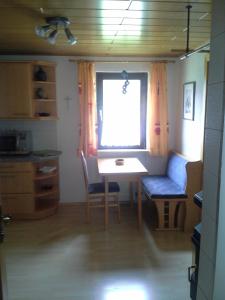 cocina con mesa, sillas y ventana en Haus Fratnik, en Obertraun