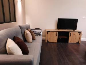 un soggiorno con divano e TV a schermo piatto di Résidence Privée entre Varengeville/mer & Dieppe a Hautot-sur-Mer