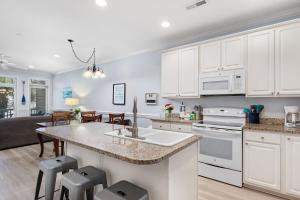 a kitchen with white cabinets and a kitchen island at Turtle BAY 10 in Folly Beach