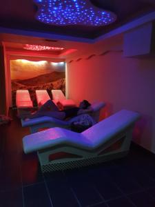 a row of beds in a room with purple lights at Milmari Premier40 in Kopaonik +22 photos