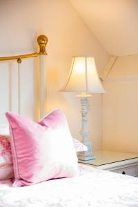 a bed with a pillow and a lamp on a table at Higher Weddicott Barn Holiday Cottage - Self Catering in Chagford