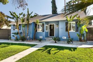 een blauw huis met palmbomen ervoor bij Le Bleu House - Newly Designed 3BR HOUSE & POOL by Topanga in Los Angeles