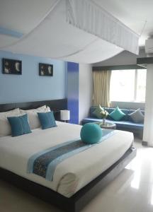 a bedroom with a large bed and a couch at Benyada Lodge - Surin Beach in Surin Beach