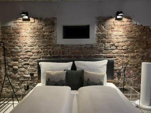 a bedroom with a brick wall and a white bed at 1Step2AllNature Tinyhouse in Wuppertal
