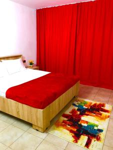 a bedroom with a bed with a red curtain at URBAN Apartment - Slatina City Centre in Slatina